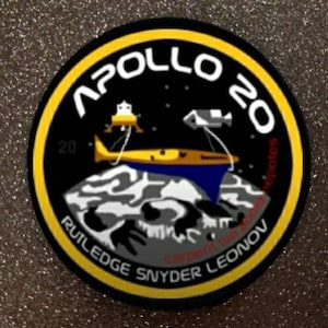 以下が含まれることがあります： 黒い背景に白い文字で「APOLLO 20」と書かれた円形のパッチ。黄色い縁取りがあり、宇宙船と月の風景が描かれています。「RUTLEDGE SNYDER LEONOV」という名前が下部に印刷されています。