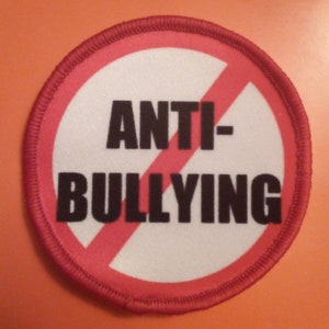 May include: A red and white circular patch with a diagonal red line through it. The text "ANTI-BULLYING" is printed in black letters.