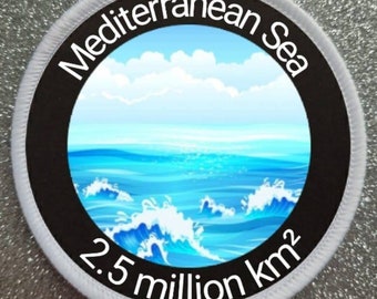 Può includere: Un cerotto rotondo bianco con un cerchio nero al centro. Il cerchio contiene un'immagine blu e bianca del Mar Mediterraneo con nuvole bianche. Il testo "Mar Mediterraneo" è scritto in bianco attorno alla parte superiore del cerchio. Il testo "2,5 milioni di km2" è scritto in bianco attorno alla parte inferiore del cerchio.