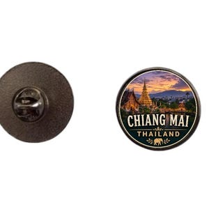 Könnte beinhalten: Runder Ansteckpin mit einer malerischen Ansicht von Chiang Mai, Thailand, mit einem goldenen Tempel und der Skyline der Stadt unter einem Sonnenuntergangshimmel. Der Pin hat einen schwarzen Rand und den Text "CHIANG MAI THAILAND".