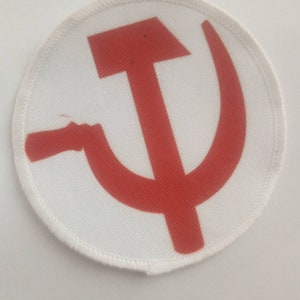 Könnte beinhalten: Ein weißer runder Patch mit einem roten Hammer-und-Sichel-Symbol in der Mitte.
