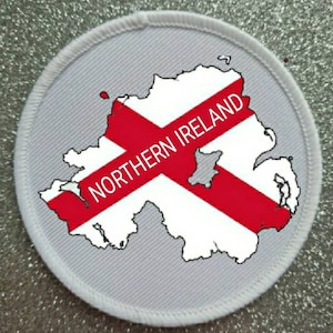 May include: White fabric patch with a red and white outline of Northern Ireland and the text "NORTHERN IRELAND" in red.