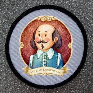 Puede incluir: Un parche redondo de tela gris y negro con una ilustración de dibujos animados de William Shakespeare. La ilustración está rodeada de un marco dorado con fondo rojo y una cinta dorada con el texto "William Shakespeare".