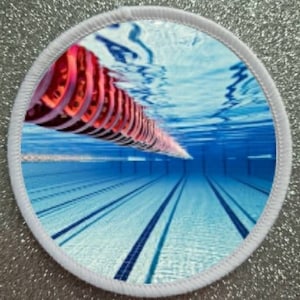 May include: An underwater view of a swimming pool with a red lane divider rope. The pool is empty and the water is clear.