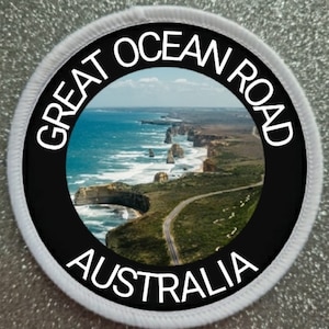 May include: A white and black round patch with the text "Great Ocean Road Australia" and a photo of a scenic coastal road in Australia.