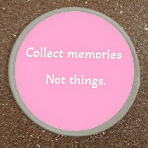Pode incluir: Um adesivo redondo rosa com uma borda branca e o texto "Collect memories Not things."