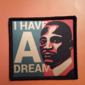 May include: A black and white patch featuring a portrait of Martin Luther King Jr. and the text "I Have A Dream".