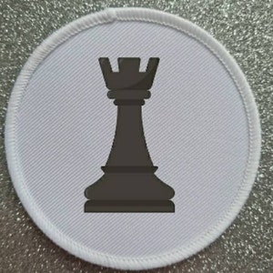 Könnte beinhalten: Ein weißer runder Aufnäher mit einer schwarzen Schach-Turm-Silhouette in der Mitte.