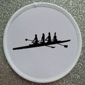 May include: White round patch with a black silhouette of a rowing team of four people in a boat with oars.