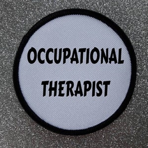 May include: White round patch with black stitching around the edge. The text "OCCUPATIONAL THERAPIST" is printed in black.