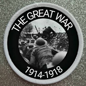 May include: A black and white circular patch with white text that reads "The Great War 1914-1918". The center of the patch features a black and white photograph of soldiers in a trench during World War I.