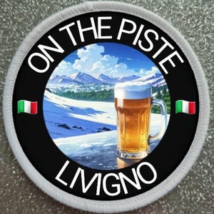Könnte beinhalten: Ein runder weißer Patch mit schwarzem Text, der "On the Piste Livigno" lautet, und einem Bild einer verschneiten Berglandschaft mit einem Glas Bier im Vordergrund. Die italienische Flagge befindet sich auf beiden Seiten des Patches.