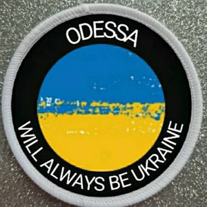 Może przedstawiać: Biała okrągła łatka z czarnym tekstem, który brzmi "ODESSA WILL ALWAYS BE UKRAINE" wokół niebiesko-żółtej flagi ukraińskiej.