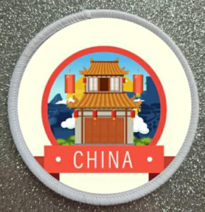 K&ouml;nnte beinhalten: Ein wei&szlig;er und roter runder Patch mit wei&szlig;em Rand. Die Mitte des Patches zeigt eine Cartoon-Illustration eines traditionellen chinesischen Geb&auml;udes mit roten Laternen. Der Text "CHINA" ist in schwarzen Buchstaben auf einem roten Banner geschrieben.