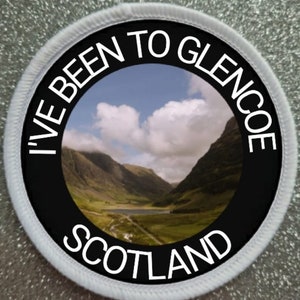 May include: A white round patch with black text that reads "I've Been To Glencoe Scotland" and a photo of a valley in the Scottish Highlands.