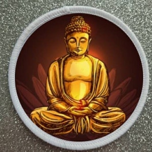 May include: A golden Buddha statue sitting in a meditative pose with a lotus flower design behind it. The statue is on a white background.