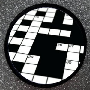Pode incluir: Um remendo redondo com um design de palavras cruzadas em preto e branco. Os números 19, 26, 27, 29 e 30 são visíveis.
