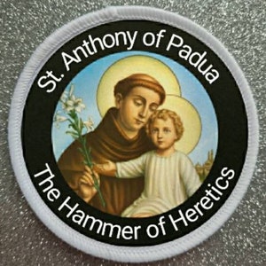 Puede incluir: Parche redondo blanco con borde negro y una imagen de San Antonio de Padua sosteniendo a un niño. El texto "St. Anthony of Padua" está escrito en un arco blanco sobre la imagen. El texto "The Hammer of Heretics" está escrito en un arco blanco debajo de la imagen.