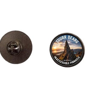 Könnte beinhalten: Ein runder Metallanstecker mit einem Fotodruck des Sgurr Dearg Inaccessible Pinnacle auf der Isle of Skye bei Sonnenuntergang. Der Text SGURR DEARG und INACCESSIBLE PINNACLE ist in Weiß entlang der oberen und unteren Kante aufgedruckt.