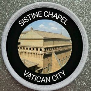 May include: A white circular patch with black text and a photo of the Sistine Chapel in Vatican City. The text reads "Sistine Chapel Vatican City".