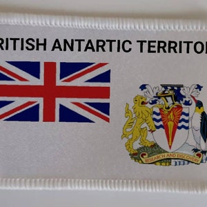 May include: A white patch with a red, white, and blue Union Jack flag on the left and the coat of arms of British Antarctic Territory on the right. The text "BRITISH ANTARCTIC TERRITORY" is printed in black at the top.