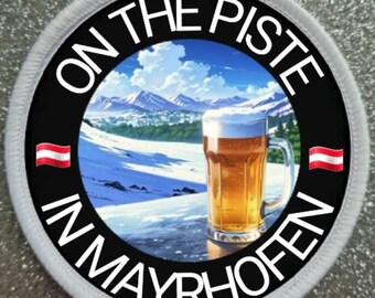 May include: A white circular patch with black text that reads "On the Piste in Mayrhofen". The patch features a cartoon image of a snowy mountain scene with a glass of beer in the foreground. The Austrian flag is on either side of the text.