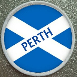 May include: A white and blue round patch with a white cross on a blue background. The word "PERTH" is written in blue letters across the cross.