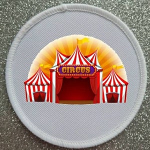 May include: White fabric patch featuring a colourful circus tent illustration. The tent has red and white stripes, a red curtain, and a purple sign that reads "CIRCUS".