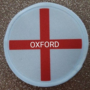 May include: A white round patch with a red cross and the word "OXFORD" in the centre.