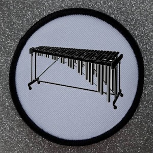 May include: A black and white illustration of a xylophone on a white background. The xylophone is on a stand with wheels.