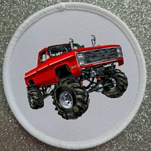 May include: A red monster truck with large tyres on a white background.
