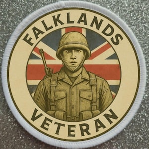 May include: Circular patch with a cream border featuring a soldier illustration in a helmet and uniform, set against a Union Jack background. The words "FALKLANDS VETERAN" are arched around the image in a serif font.