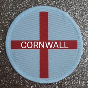 May include: A round, white patch with a red cross and the word "CORNWALL" in the center.