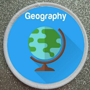 May include: A white round patch with a blue background and a globe icon. The text "Geography" is printed in white at the top of the patch.