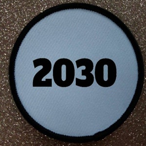 May include: A white round patch with a black border and the number 2030 printed in black.