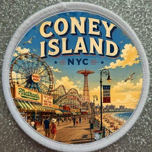 Può includere: Una toppa circolare con un'illustrazione in stile vintage di Coney Island, NYC. Il design include la ruota panoramica Wonder Wheel, le montagne russe Cyclone, uno stand Nathan's, una spiaggia e una passerella con persone sotto un cielo blu.