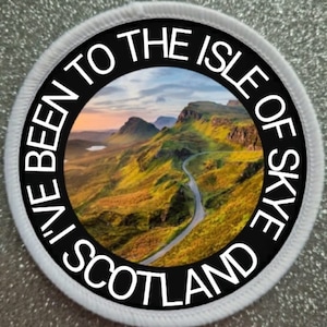 May include: A white round patch with black text that reads "I've Been To The Isle Of Skye Scotland". The centre of the patch features a photo of a winding road through a green, mountainous landscape.