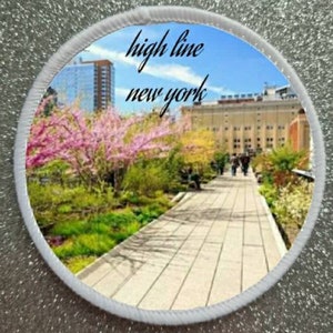 May include: A circular patch with a white border and a photo of a walkway in a park. The text "high line new york" is printed in black on the patch.