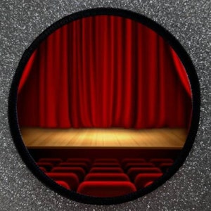 May include: A round patch with a red stage curtain and wooden stage floor. The stage is empty and there are rows of empty seats in the foreground.