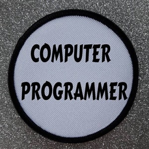 Peut inclure: Écusson rond blanc avec des coutures noires autour du bord. Le texte "COMPUTER PROGRAMMER" est imprimé en lettres noires en gras.