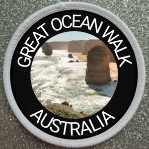 May include: Circular patch featuring the text "GREAT OCEAN WALK AUSTRALIA" in white on a black band. The central image depicts a coastal scene with sea stacks and ocean waves.