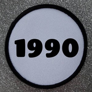 May include: White round patch with a black border and the year 1990 printed in black.