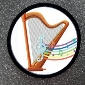 May include: A white patch with a black border features a colorful illustration of a harp with musical notes and a treble clef. The harp is brown with a white string pattern.