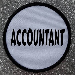 May include: White round patch with a black border and the word "ACCOUNTANT" in bold black letters.
