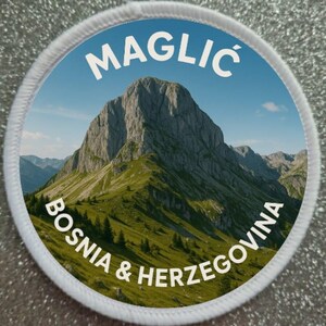 May include: A round patch featuring a mountain landscape with the text "MAGLIC" at the top and "BOSNIA & HERZEGOVINA" at the bottom. The patch has a white border and a blue sky background.