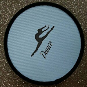 May include: A light blue round patch with a black border. The patch features a silhouette of a dancer in mid-air with the word "Dance" written in cursive below the dancer.