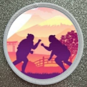 May include: Two purple silhouettes of people fighting in a sunset landscape with a mountain in the background. The scene is framed by a white circle with a gray border.