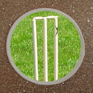 May include: A close-up of a set of white cricket wickets on a green grass field. The wickets are made of wood and have a traditional design.