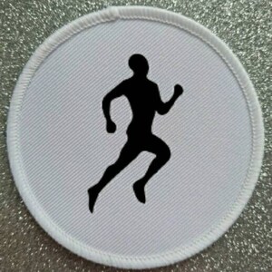 May include: White round patch with a black silhouette of a runner. The runner is in mid-stride with their arms bent at the elbows.