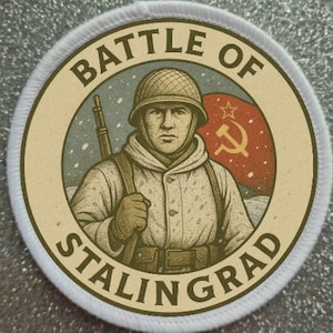 May include: A circular patch featuring a soldier in a winter uniform, holding a rifle, with the text "BATTLE OF STALINGRAD." A red flag with a hammer and sickle is in the background. The patch has a cream-colored border.